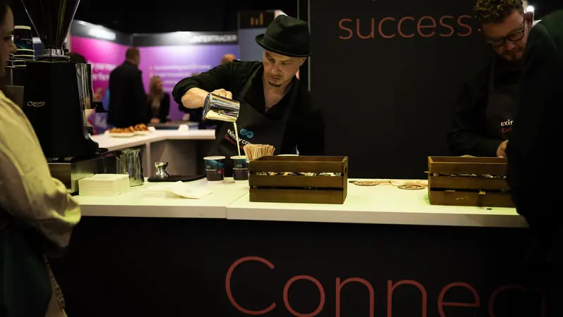 Barista making coffee at a branded coffee bar during a corporate exhibition