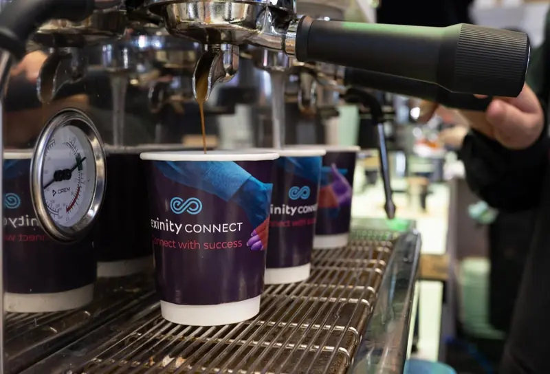 Branded Exinity Connect coffee cups filled at a Mr Flavour barista station at the Finance Magnates London Summit