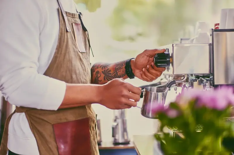 Barista pouring a latte at a branded office coffee bar