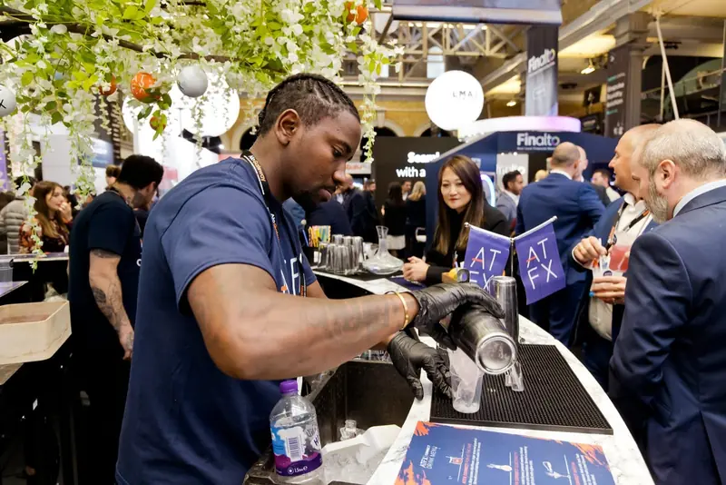 A Mr Flavour bartender serving branded drinks to delegates at the Finance Magnates London Summit