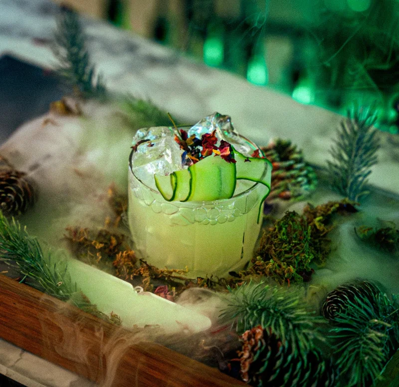 Aston Martin signature cocktail with a cucumber ribbon and pine garnish, created by Mr Flavour