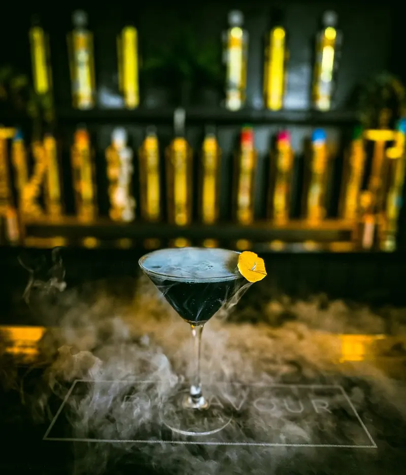 Smoking cocktail on a branded Mr Flavour bar top beneath neon tubes