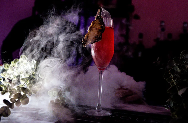 Spritz cocktail with a dried fruit garnish, finished with dry ice rolling across the bar