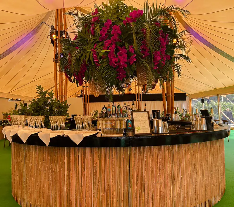 Curved garden bar under a floral canopy, ready for a wedding reception
